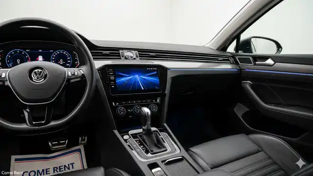 Volkswagen Passat'ın dijital gösterge paneli ve dokunmatik ekranlı lüks iç mekanı, Come Rent logosu sol altta yer alıyor