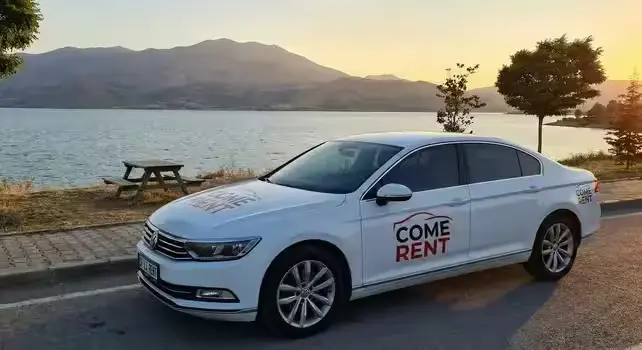 Elazığ'da bir göl kenarında park etmiş, Come Rent logosulu beyaz Volkswagen Passat