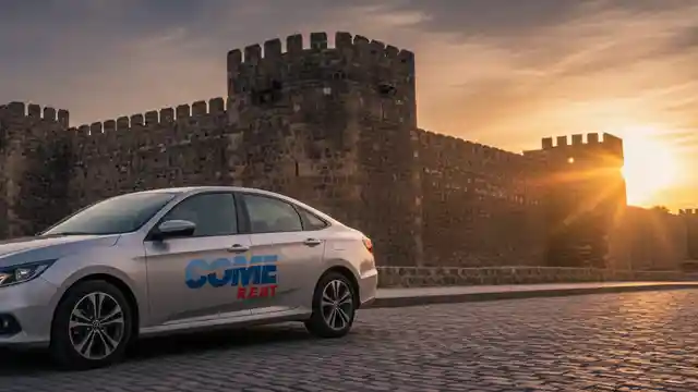 Gün batımında Kayseri Kalesi'nin heybetli surları önünde duran modern bir sedan araç