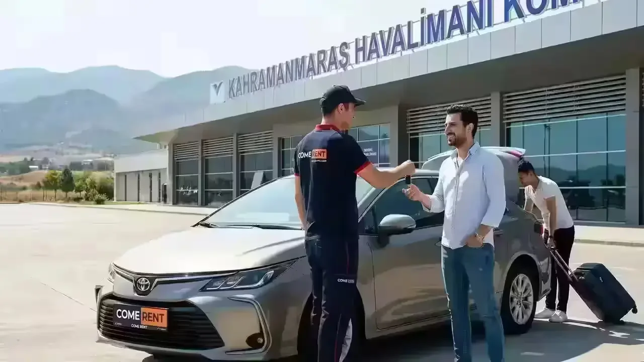 Der Moment, in dem ein Vertreter von Come Rent vor dem Terminal des Flughafens Kahramanmaraş die Schlüssel für den Mietwagen an einen Kunden übergibt.